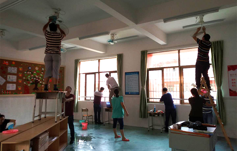 6686体育志愿者及家长拆洗风扇和擦拭窗户