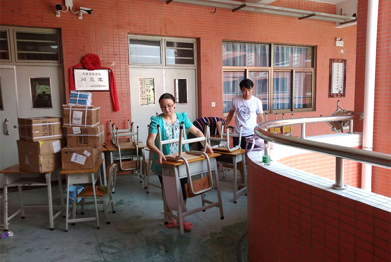 6686体育志愿者及家长用消毒液擦拭桌椅